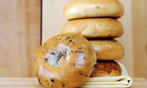 Pile de bagels, dont un aux myrtilles en premier plan. Parfait pour une recette bagel maison.