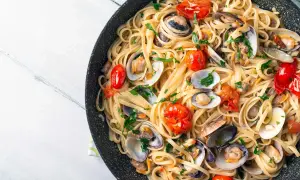 Spaghetti aux fruits de mer, un plat italien savoureux avec des palourdes, des tomates cerises et du persil frais.
