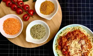 Spaghetti al pomodoro avec lentilles corail, tomates cerises, curcuma et anis étoilé. Un plat savoureux et coloré.