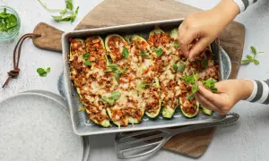 Courgettes farcies à la viande hachée, gratinées au fromage et garnies d'herbes fraîches. Une recette savoureuse prête à être dégustée.