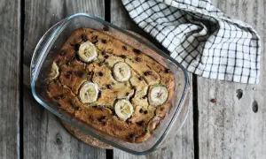 Un délicieux banana bread sans gluten, garni de rondelles de banane et de pépites de chocolat, sort tout juste du four.