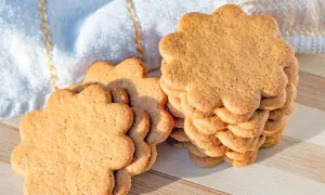 Délicieux biscuit sans beurre avec huile, en forme de fleur, empilés sur une planche en bois.