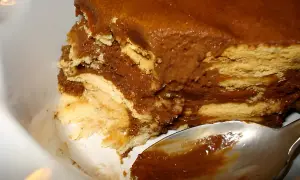 Délicieux gâteau sans cuisson aux couches de biscuits et de crème au chocolat, prêt à être dégusté avec une cuillère.