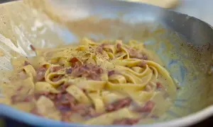 Fettuccine alla papalina crémeux et poivré, servi dans une poêle.