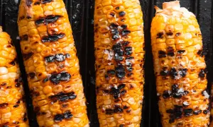 Épis de maïs dorés, parsemés de gros sel, avec des marques de cuisson bien visibles. Un délice grillé !