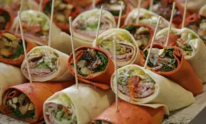 Plateau de wraps colorés, parfaits pour une recette facile et rapide. Garnitures variées visibles : légumes, charcuterie, sauce.