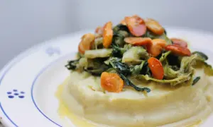 Purée crémeuse surmontée de fave et cicoria, un plat végétarien savoureux.