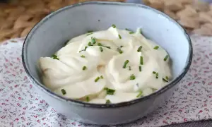 Un bol de mayonnaise sans huile, onctueuse et garnie de ciboulette fraîche. Parfaite pour accompagner vos plats.