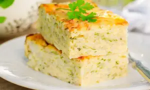 Deux parts de flan de courgettes facile, garnies de persil frais, sur une assiette blanche.