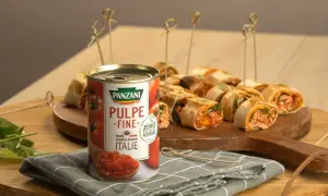 Délicieux wrap poulet garni de pulpe de tomate Panzani, présenté sur un plateau en bois avec des brochettes.