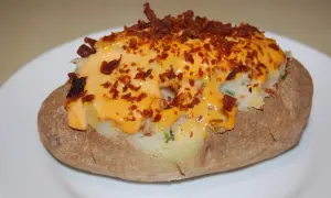 Pommes de terre farcies, généreusement garnies de fromage fondu et de bacon croustillant. Un délice réconfortant.