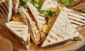 Tramezzini recette : des sandwichs triangulaires grillés, garnis de légumes frais et de garnitures savoureuses, prêts à être dégustés.