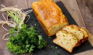 Un délicieux cake au thon, doré et moelleux, coupé en tranches. Accompagné de persil frais, parfait pour une recette facile.