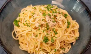 Délicieuses pâtes au thon, une recette simple et savoureuse, garnie de persil frais et de poivre noir.