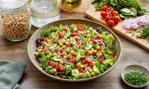 Salade composée fraîche et colorée avec pois chiches, tomates cerises, concombre et oignons rouges. Un délice sain et léger.