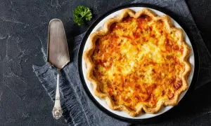 Une délicieuse tarte au fromage dorée, prête à être servie avec une touche de persil.