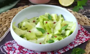Salade fraîche de courgettes crues marinées au vinaigre, parsemée de baies roses et de menthe.