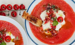Soupe à la tomate rafraîchissante avec burrata, tomates cerises, oignons rouges, basilic et croûton grillé. Un délice estival.