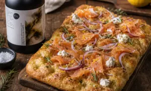 Délicieuse focaccia italiana garnie de saumon fumé, oignons rouges, fromage frais et romarin. Parfait pour un apéritif gourmand.