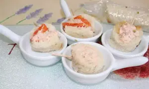 Petites bouchées de pain garnies de rillettes de saumon, présentées dans des cuillères de service.