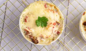 Un gratin de brocolis crémeux et doré, garni d'une feuille de persil, prêt à être dégusté.