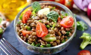 Salade de lentilles traditionnelle, fraîche et colorée, garnie de tomates cerises, concombre et oignons verts. Un délice sain.