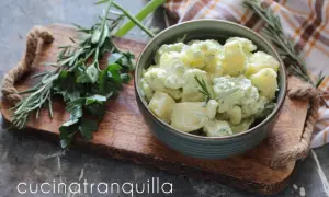 Salade de pommes de terre crémeuse, assaisonnée de yaourt et de moutarde, garnie d'herbes fraîches.