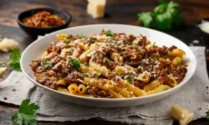 Un plat généreux de pâtes penne, nappées d'une sauce riche et savoureuse, rappelant la tradition de la pasta alla genovese. Saupoudré de parmesan et garni de persil frais.