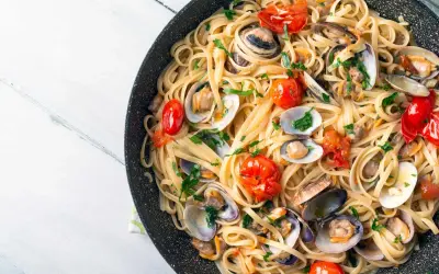 Spaghetti aux fruits de mer, un plat italien savoureux avec des palourdes, des tomates cerises et du persil frais.
