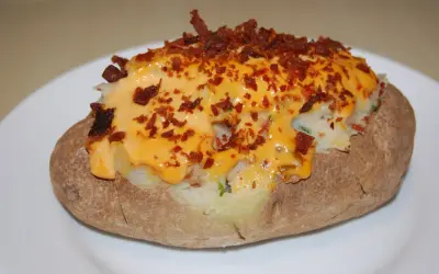 Pommes de terre farcies, généreusement garnies de fromage fondu et de bacon croustillant. Un délice réconfortant.