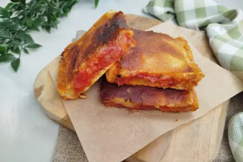Une parigina napoletana dorée et croustillante, garnie de sauce tomate et de fromage fondant, prête à être dégustée.