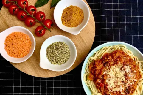 Spaghetti al pomodoro avec lentilles corail, tomates cerises, curcuma et anis étoilé. Un plat savoureux et coloré.