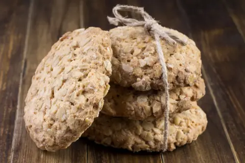 Biscuits aux flocons d'avoine, liés par une ficelle, sur fond de bois. Parfait pour une recette flocon d'avoine maison.