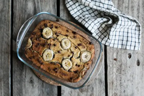 Un délicieux banana bread sans gluten, garni de rondelles de banane et de pépites de chocolat, sort tout juste du four.
