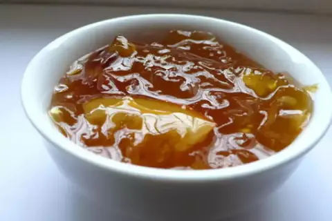 Un bol de pastèque confite, d'une belle couleur ambrée, reflétant la lumière.