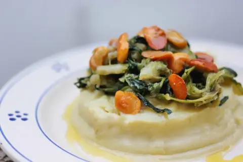 Purée crémeuse surmontée de fave et cicoria, un plat végétarien savoureux.