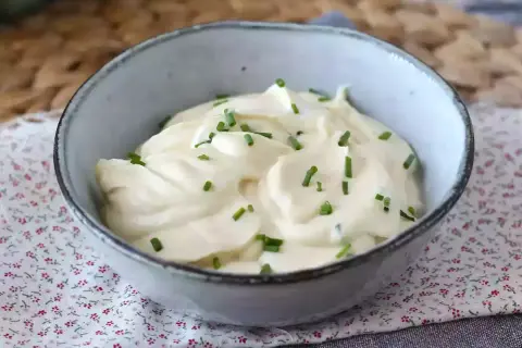 Un bol de mayonnaise sans huile, onctueuse et garnie de ciboulette fraîche. Parfaite pour accompagner vos plats.