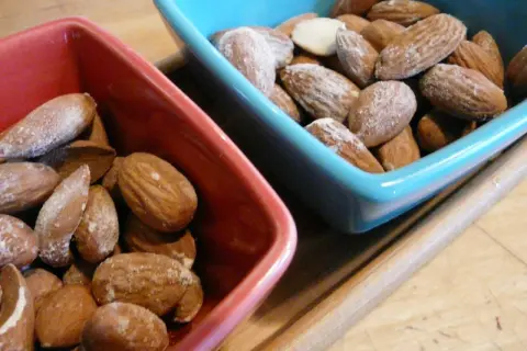 Deux bols, un rouge et un bleu, remplis d'amandes salées. Parfait pour un apéritif !