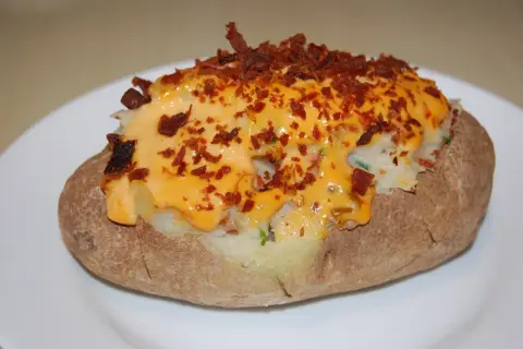Pommes de terre farcies, généreusement garnies de fromage fondu et de bacon croustillant. Un délice réconfortant.