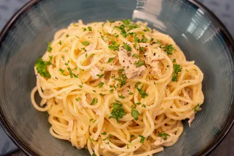 Délicieuses pâtes au thon, une recette simple et savoureuse, garnie de persil frais et de poivre noir.