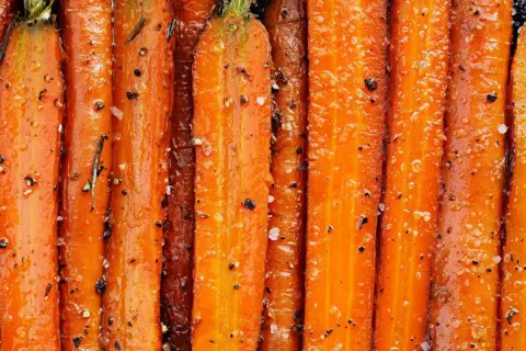 Carottes entières, caramélisées et assaisonnées de sel et de poivre, prêtes à être dégustées. Un délice de carotte à la poêle.