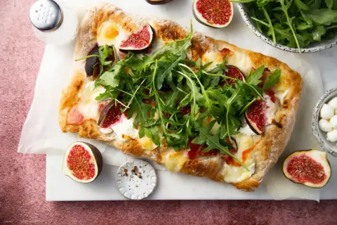 Découvrez 15 recettes étonnantes à la figue fraîche : une pizza gourmande garnie de figues, roquette et mozzarella.