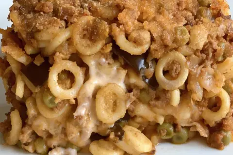 Un plat d'annelletti al forno, avec des pâtes en anneaux, de la viande hachée, des petits pois et du fromage fondant, le tout gratiné.