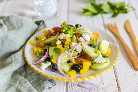 Salade de petit épeautre à la grecque, colorée et fraîche, avec concombre, tomates, poivrons, olives, oignons rouges et feta.