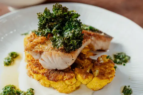 Un délicieux poisson poêlé sur un lit de chou-fleur doré, garni de kale croustillant. Une recette chou-fleur à la poêle qui éveille les papilles.