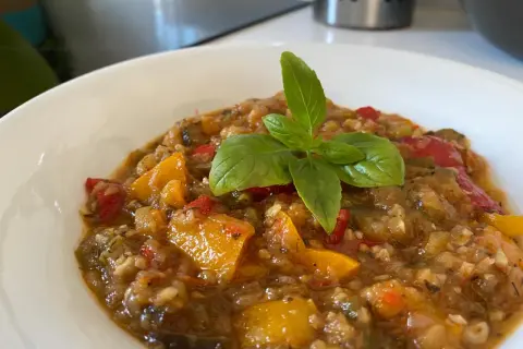 Ratatouille coloré et savoureux, préparé avec le Cookeo, garni d'une feuille de basilic frais.