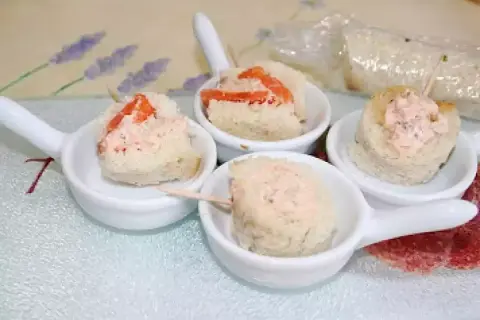 Petites bouchées de pain garnies de rillettes de saumon, présentées dans des cuillères de service.