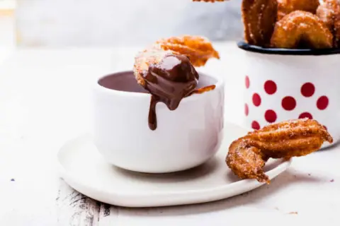 Churros dorés et croustillants, parfaits pour une recette facile à tremper dans un chocolat chaud onctueux.