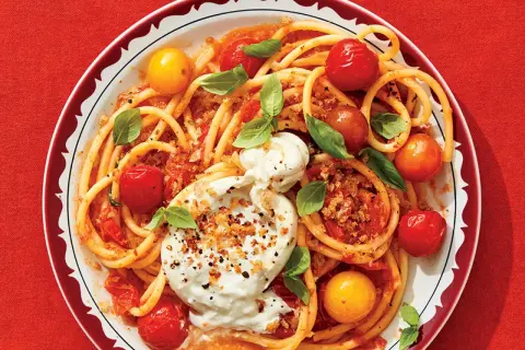 Délicieuse recette de paccheri avec tomates cerises, burrata crémeuse et basilic frais. Un plat coloré et savoureux.
