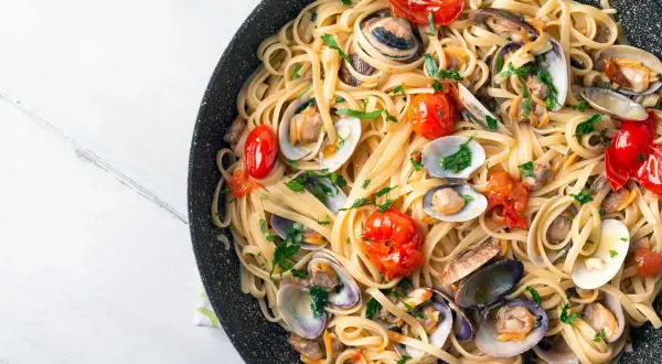 Spaghetti aux fruits de mer, un plat italien savoureux avec des palourdes, des tomates cerises et du persil frais.